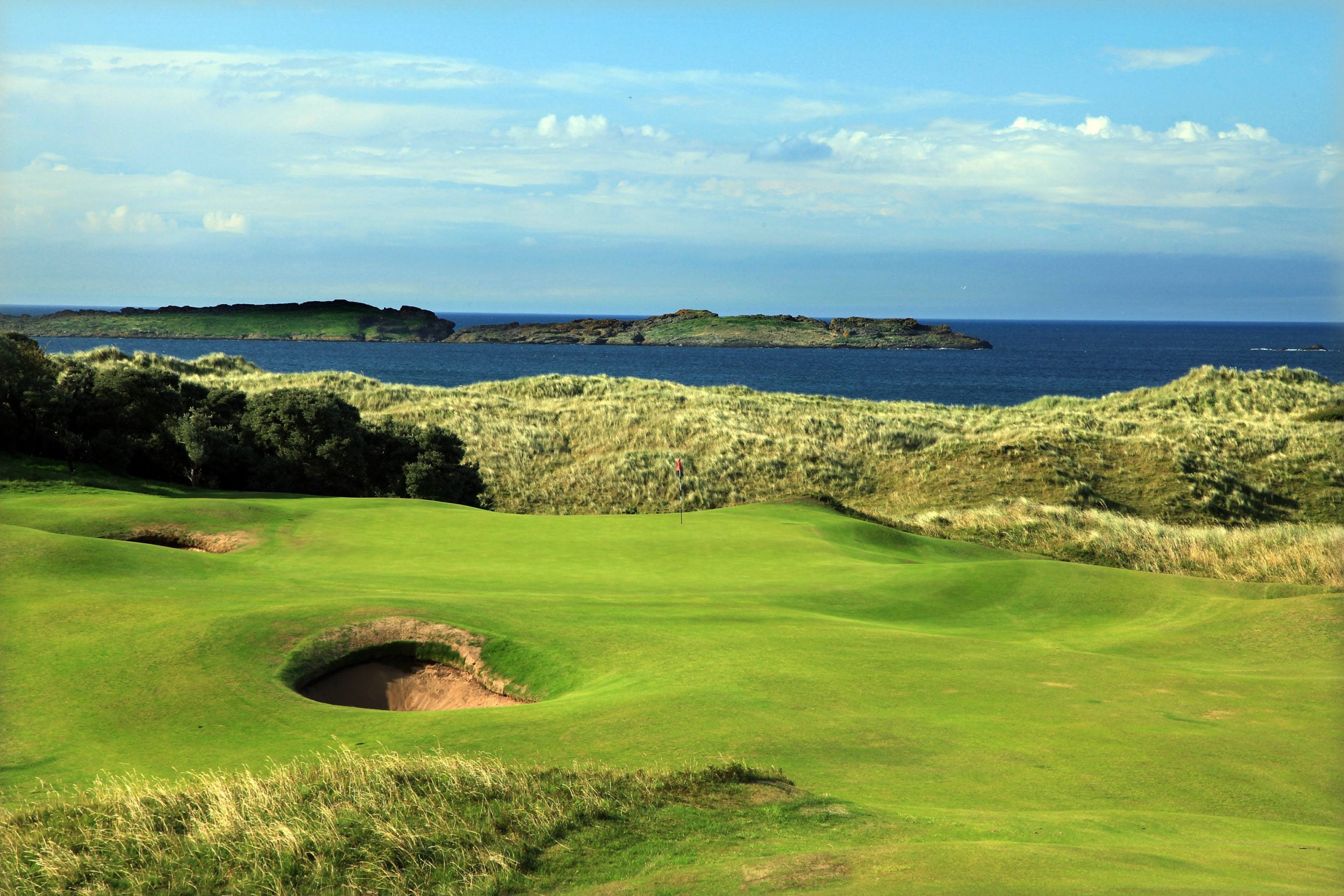 Image depicting a big pot bunker and raised green with the ocean in the background, Royal Portrush Dunluce Golf Course, Portrush, County Antrim, Northern Ireland