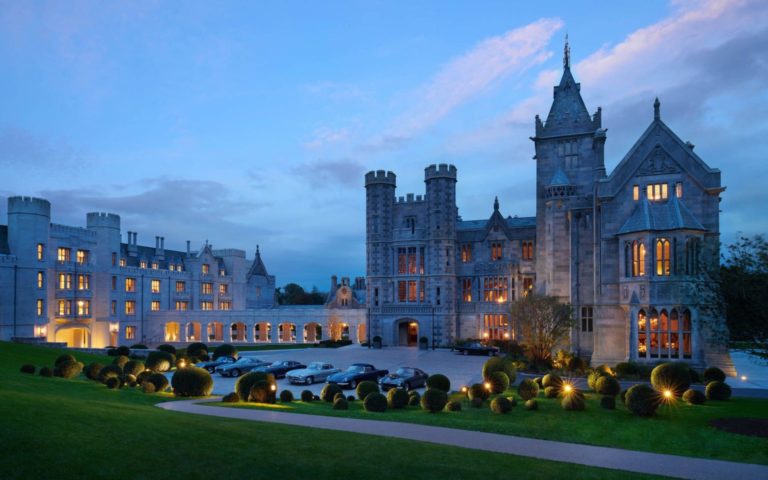 Twilight image of vintage cars parked outside the manor entrance at Adare Manor, County Limerick, Ireland, Europe