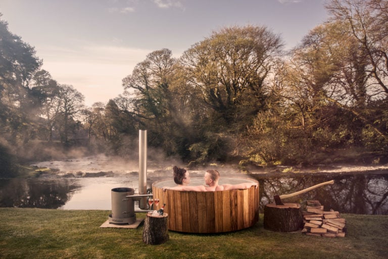 Image depicting two people bathing in a hot tub by the river at Galgorm Resort, County Antrim, Northern Ireland