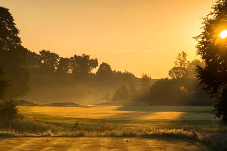 Image of morning mist in the sunshine rising above the 15th green, Galgorm Resort, County Antrim, Northern Ireland
