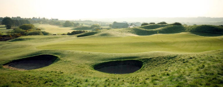 Image depicting a bunker and green shrouded in early morning mist at Dooks Golf Club, County Kerry, Ireland
