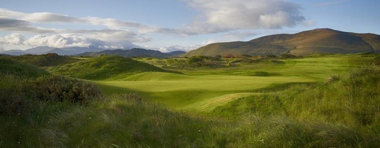 Image depicting the 14th green and distant mountains at Dooks Golf Club, County Kerry, Ireland