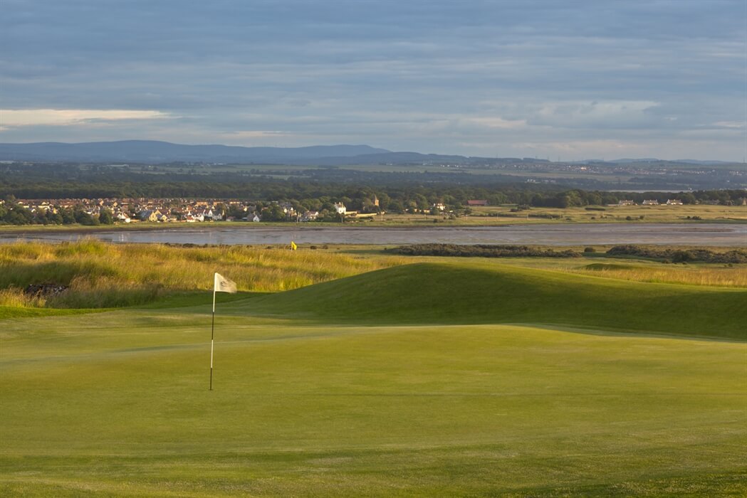 Image of a green and flag in the foreground and the town in the backgound, Gullane No.2 Golf Course, East Lothian, Scotland, United Kingdom