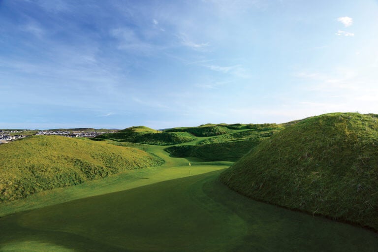 Image of the 5th green surrounded by cavernous grassy dunes on the old golf course at Lahinch Golf Club, County Clare, Ireland