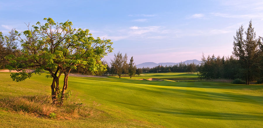 Image of the sun setting on the 16th hole at Montgomerie Links Vietnam Golf Course, Da Nang, Vietnam, Asia