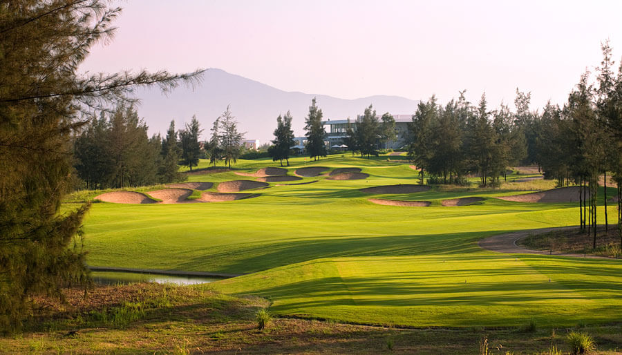 Image looking down the signature 12th hole and distant clubhouse at Montgomerie Links Vietnam Golf Course, Da Nang, Vietnam, Asia
