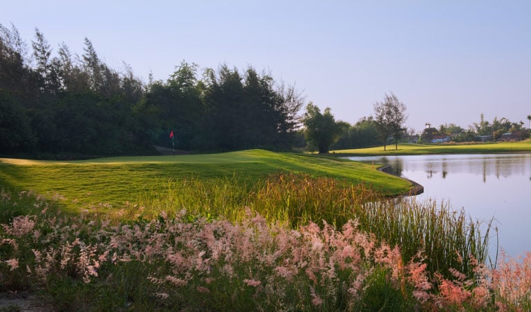 Image of the 5th green beside a lake at the Montgomerie Links Vietnam Golf Course, Da Nang, Vietnam, Asia