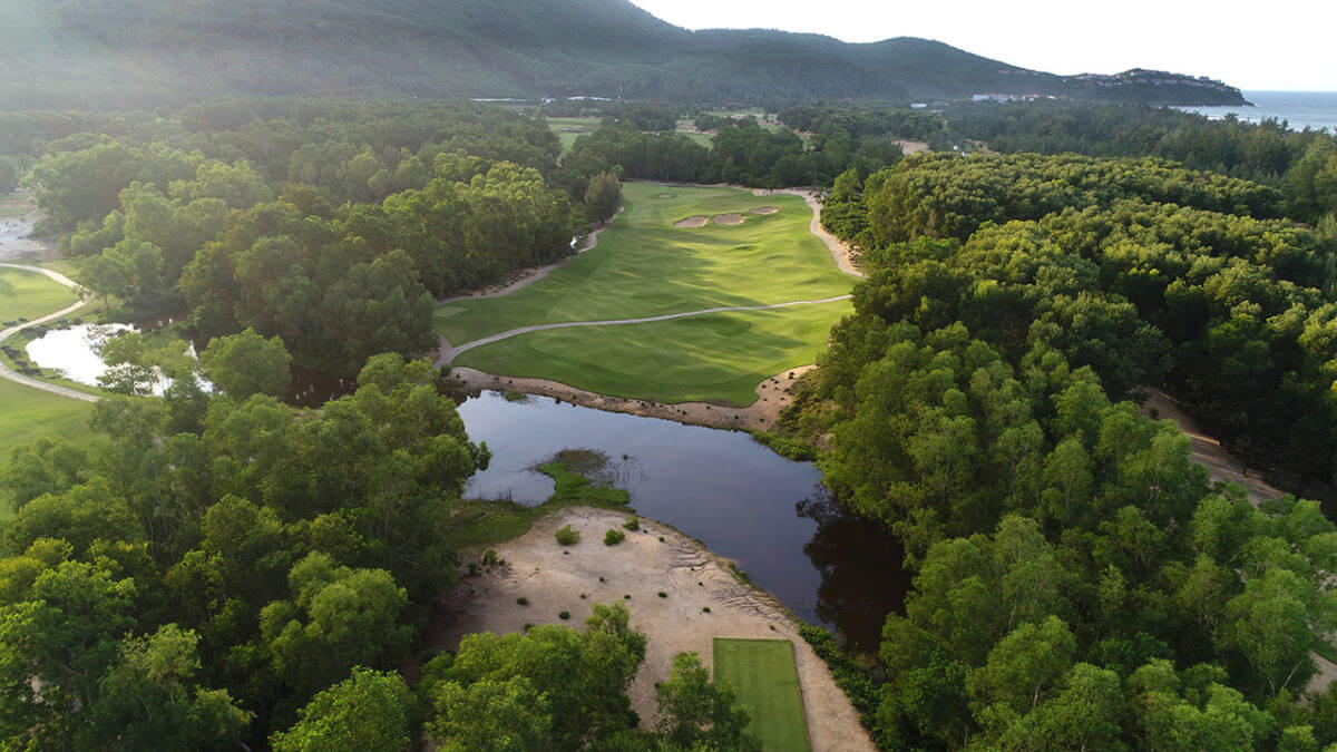 Aerial image of the 12th tee box and fairway inter crossed by a lake, at Laguna Lang Co Golf Club, Da Nang, Vietnam
