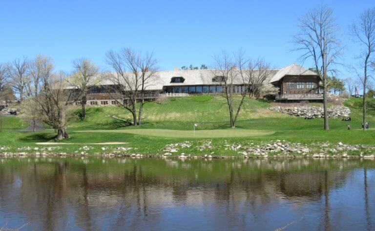 Image of the 18th hole of The River Course at Blackwolf Run and the clubhouse in the background