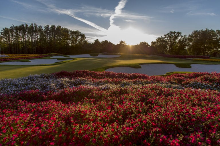 Red flowers surround the sixteenth green at Sentryworld golf club
