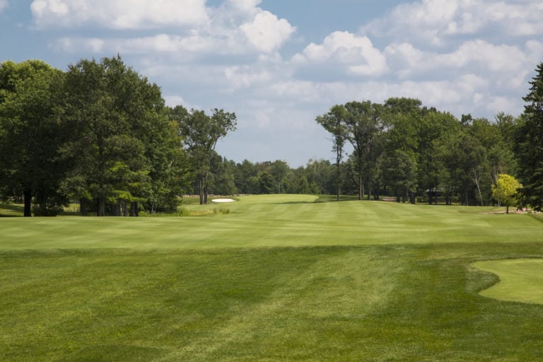 Lush fairways flanked by tall trees at Sentryworld Golf Course