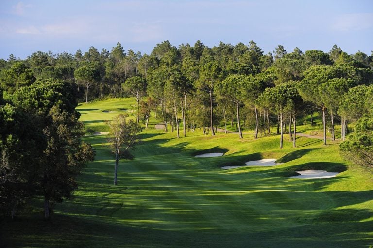 Overlooking a golf fairway lined with bunkers and tall pine trees