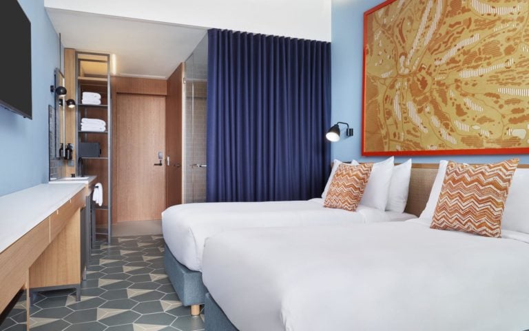 A twin bed-room with contemporary decor awaits guests at PGA Catalunya Lavida Hotel
