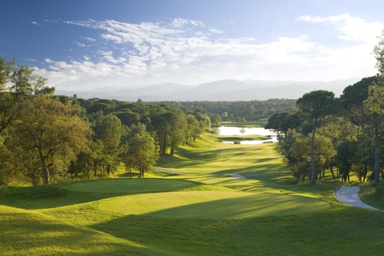 Overlooking wide fairways flanked by green forests on the thirteenth hole of the PGA Catalunya golf course