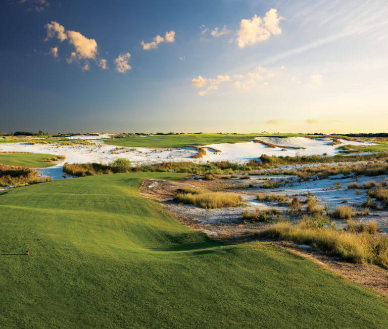 Large sandy bunkers separate a fairway from the tee box on the Black Golf Course at Streamsong Resort in Florida