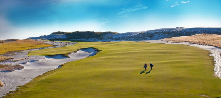 Two golfers walk the Red Golf course eighteenth hole at Streamsong Golf Resort, Florida
