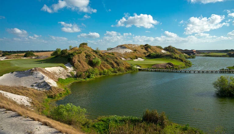 Large sand dunes and lake surround the seventh green on the Streamsong Blue Golf Course