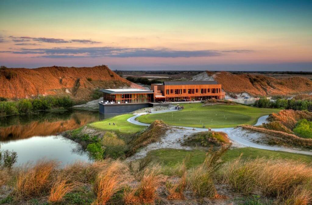 Golden dusk sunlight touches the practice golf facilities and clubhouse at Streamsong Golf Resort in Florida