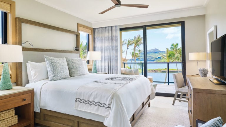 A Maliula bedroom has contemporary furniture and balcony that overlooks the Pacific Ocean at Timbers Resort