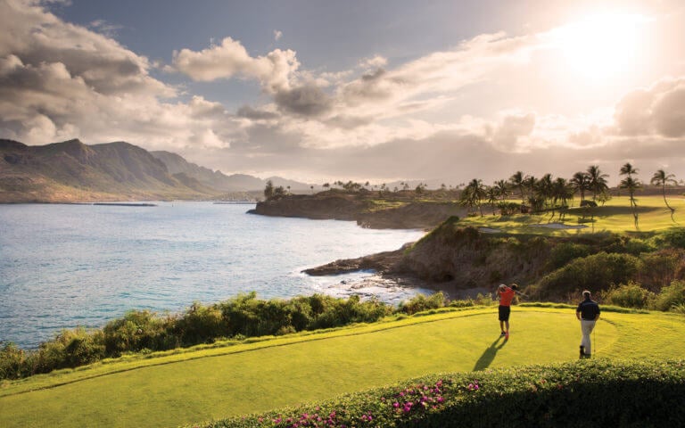 A golfer tee's off over a sea ravine on the Ocean Course at Hokuala in Kauai