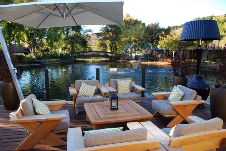 Lounge dining area and umbrella overlook a tranquil lake at Quail Lodge Resort in California