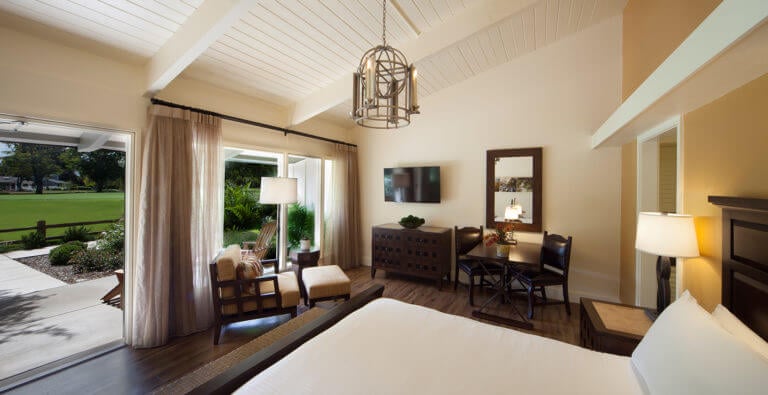 A patio bedroom and large king bed lie in a Quail Lodge Bedroom