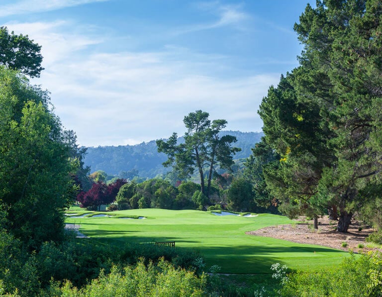 Looking down the fairway of the twelfth hole surrounded by large pine trees at Quail Lodge in California