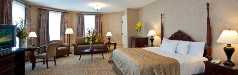 A large king bed and separate seating area in a Springs Hotel Room at French Lick Golf Resort, Indiana