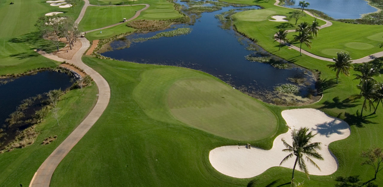 Aerial image of a lake next to sandy bunker and green at PGA National Golf Resort in Florida
