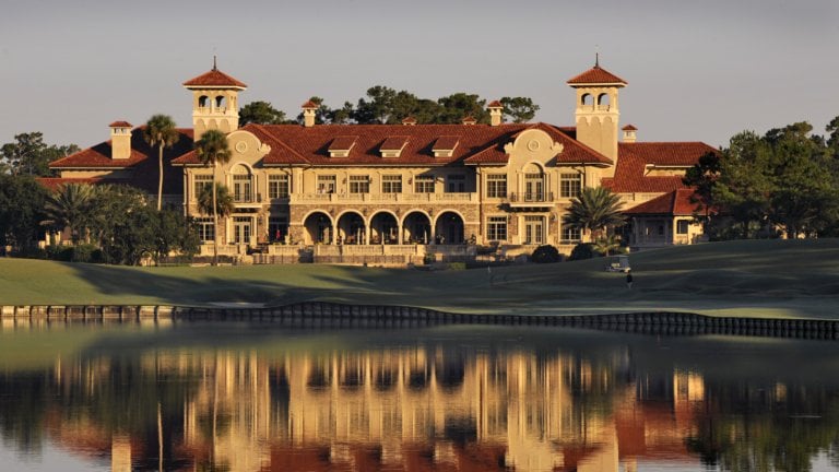 Dusk shines golden light on the golf course clubhouse at TPC Sawgrass