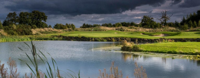 A landscape view of a lake and distant golf green on The K Club's Smurfit Golf Course, Ireland