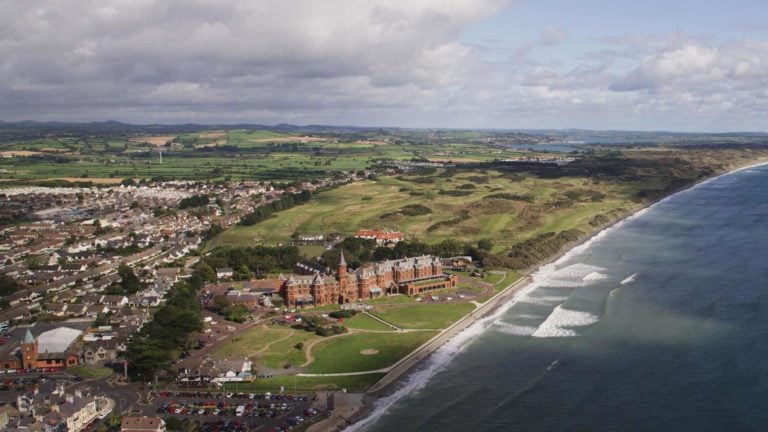 Aerial view of the Slieve Donard township and the Royal County Down golf complex next to the sea