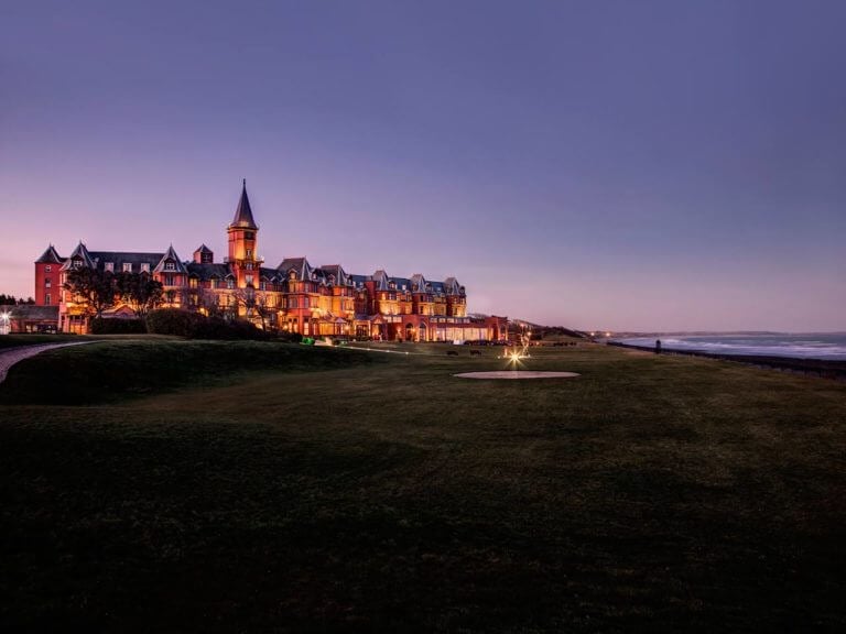 Exterior view of the main resort building and front lawn looking down the coast at Slieve Donard Hotel