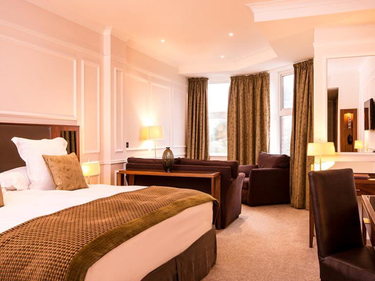 A large king bed and separate seating area at the Slieve Donard Hotel