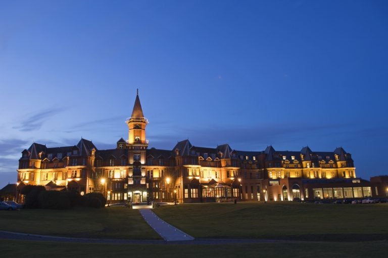 Exterior twilight view of lights and the main resort building at the Slieve Donard Hotel