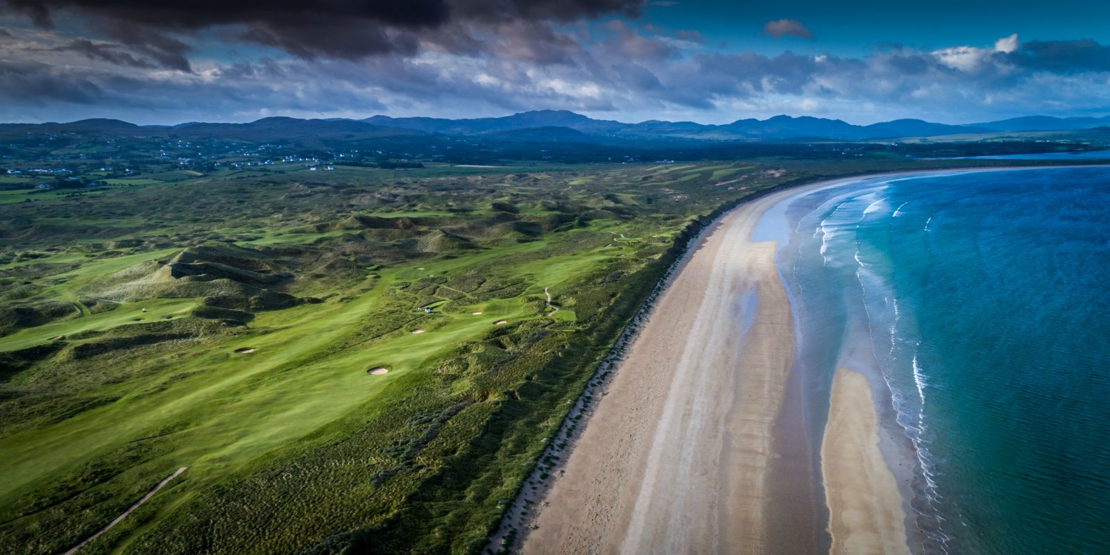 Aerial view of the ocean contrasting with the beach and golf courses at Rosapenna Golf Resort, Ireland