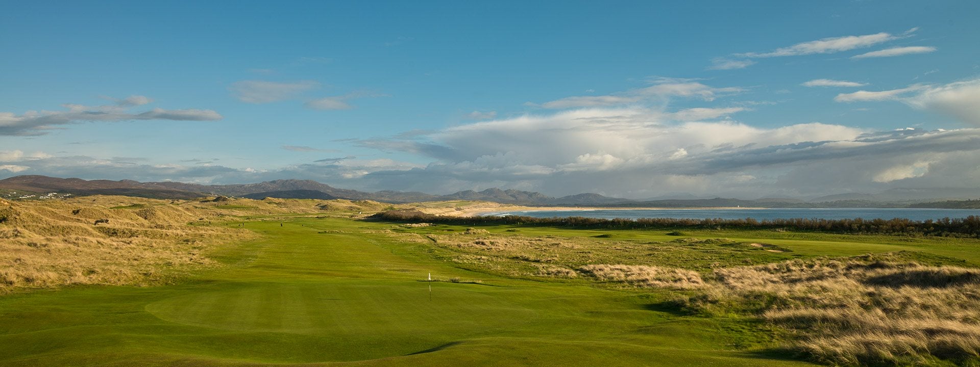 Landscape view of a green and long hazardous grass on the Old Tom Morris golf course at Rosapenna Golf Resort, Ireland