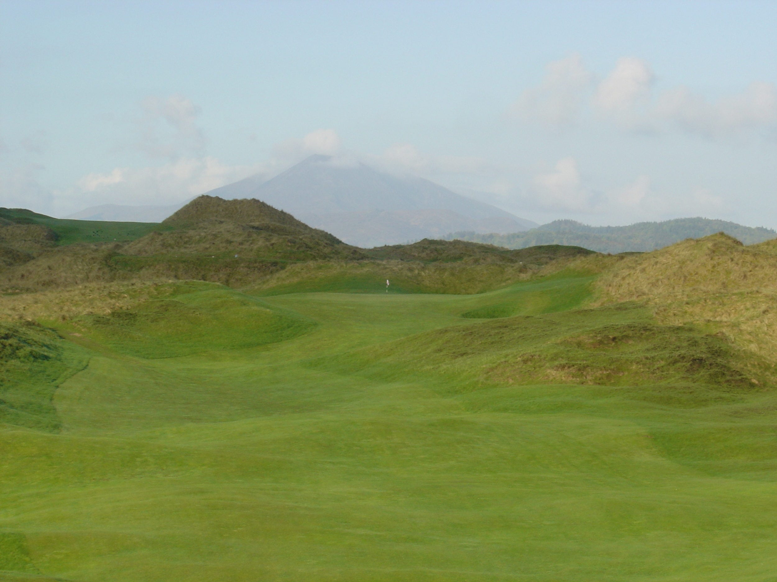 Undulating fairways lead up to a distant green at Rosapenna Golf Resort, Ireland