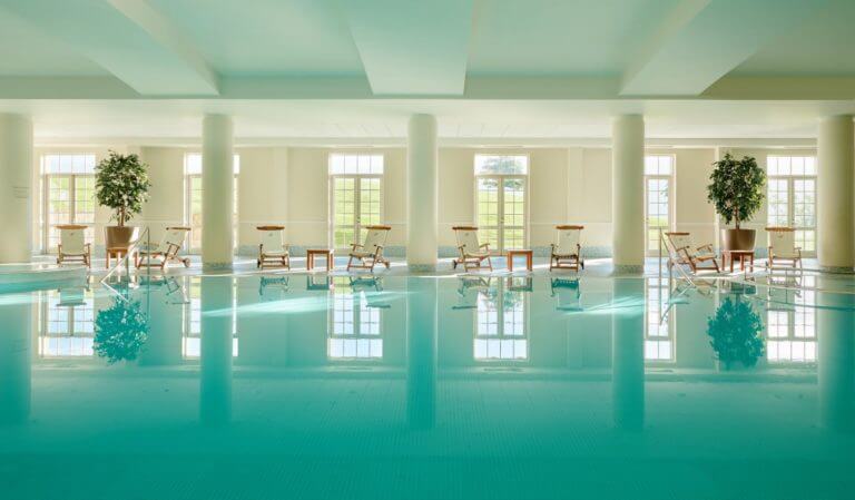 A large indoor pool and lounge seating inside The Fairmont Hotel, St Andrews
