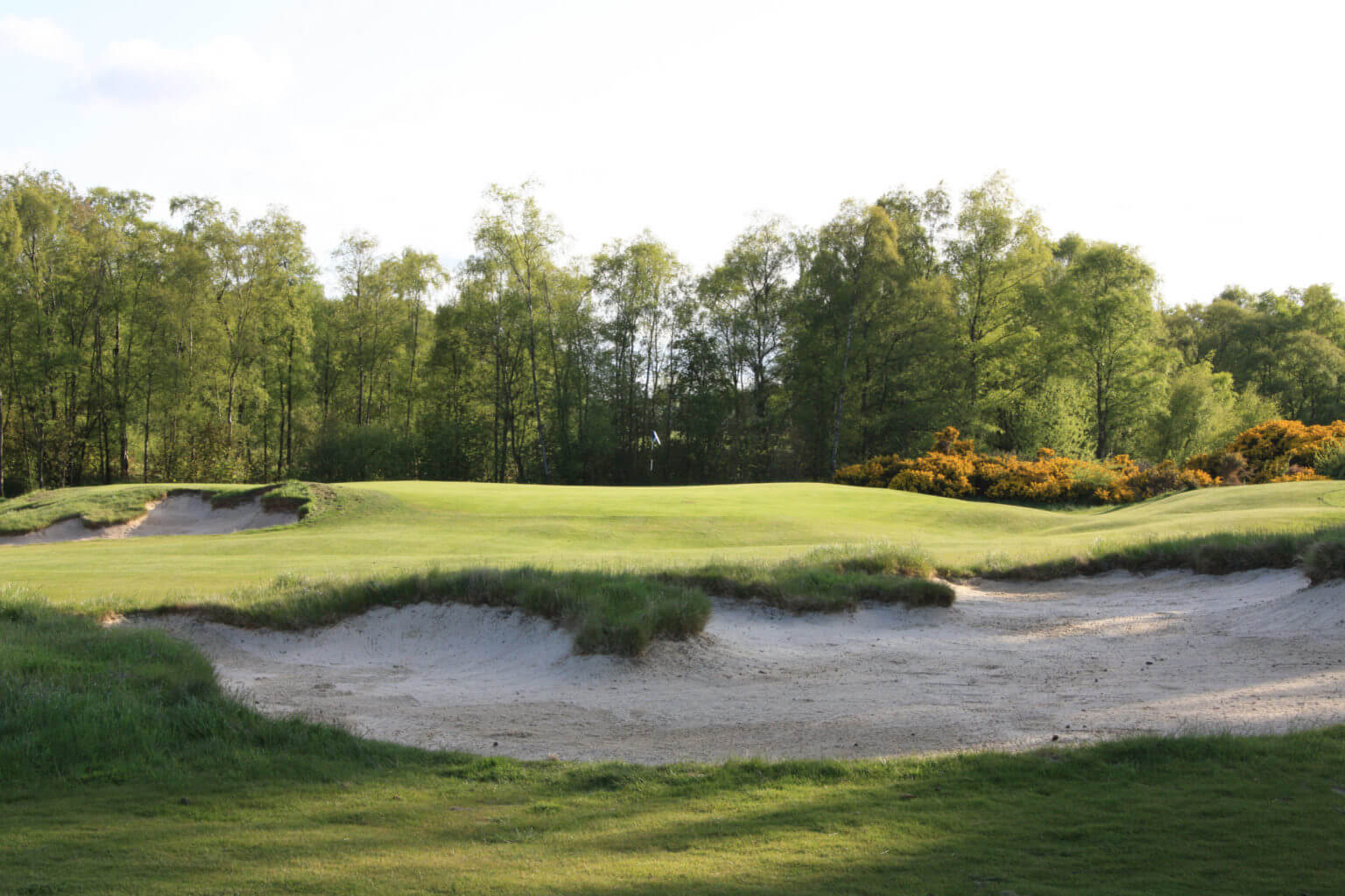 Image of a bunker and first green at Duke's Golf Course