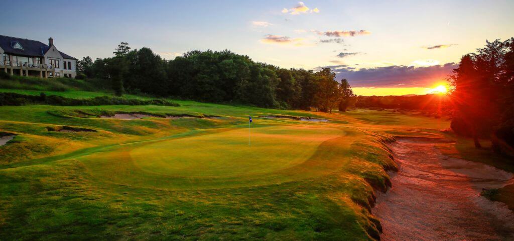 A golden sun sets on a green at Duke's Golf Course