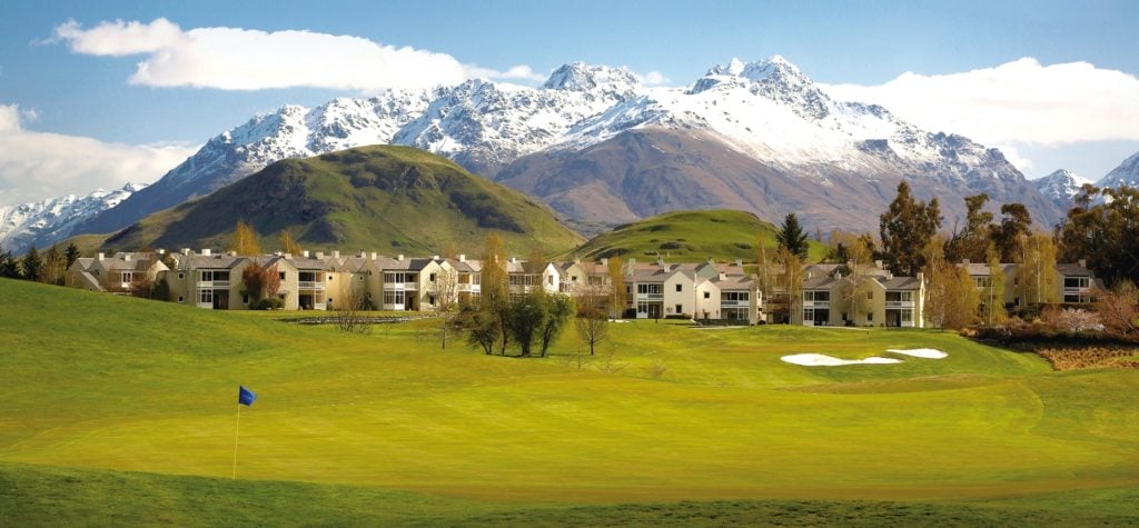 Landscape view of the Millbrook Resort's Golf Course, accommodation and background snow-capped mountains