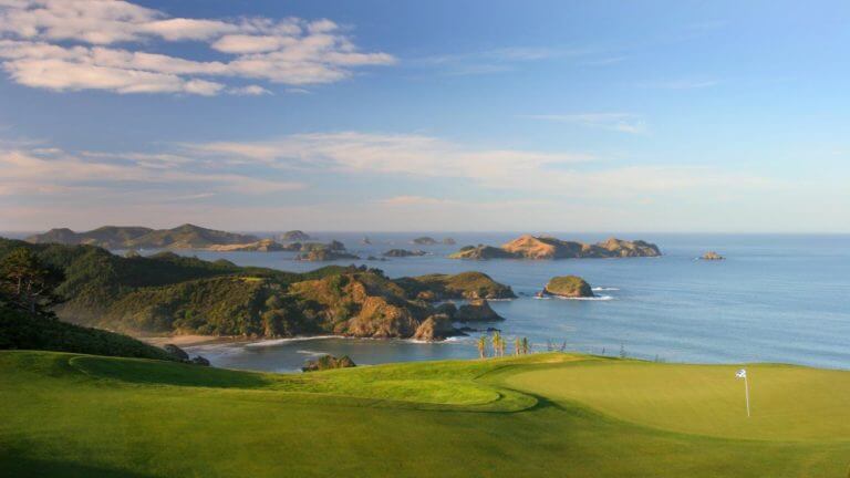 Image of the sun setting over the Kauri Cliffs Golf Course and Bay of Islands, New Zealand