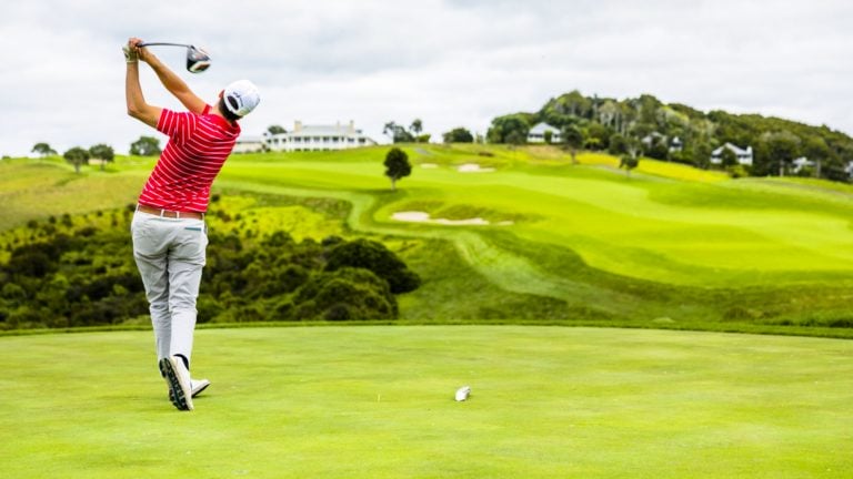 A golfer tee's off at Kauri Cliffs 18th hole, New Zealand's North Island