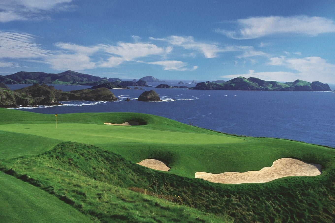 Image of low bunkers leading to a plateaued green at Kauri Cliffs Golf Resort, New Zealand's North Island