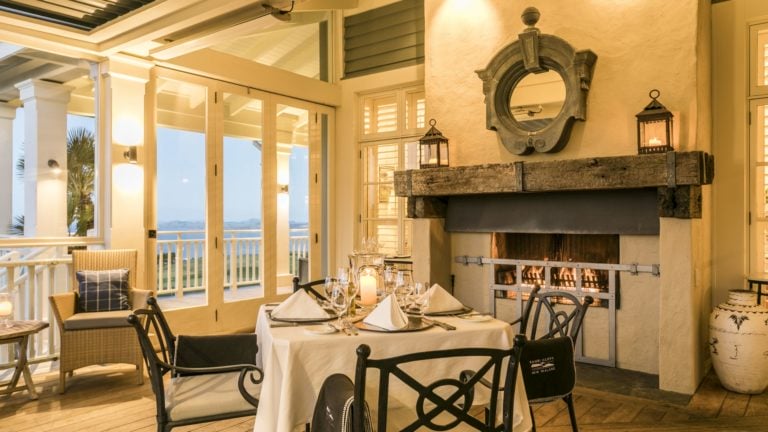 Image of fine-dining in front of a log fire at Kauri Cliffs Golf Resort