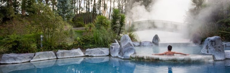 Man bathing in a geothermal pool in the Wairakei Terraces, New Zealand