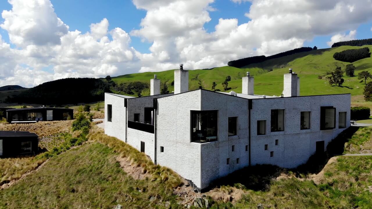 Exterior view of The Kinloch Manor and far green ridge-line