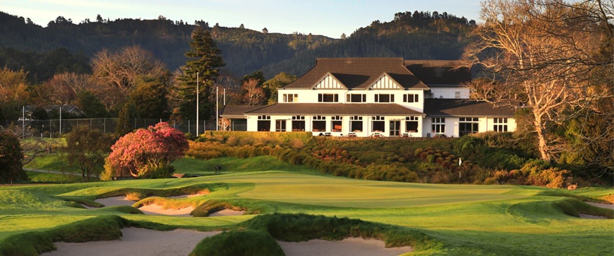 The 18th green sits below a dusk-covered clubhouse at Royal Wellington Golf Club