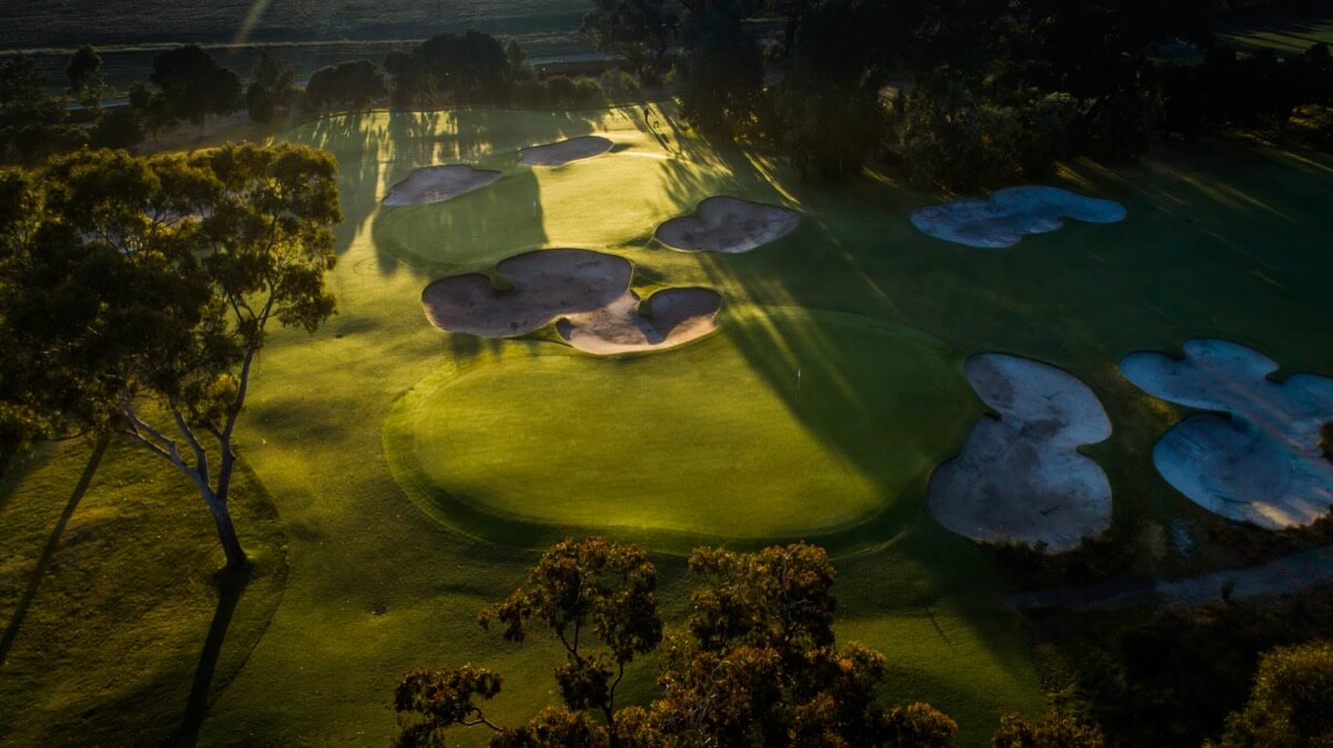 Shadows merge with shafts of light on the Commonwealth Golf Club Course green